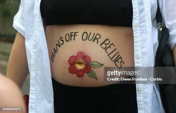 Woman with the words "Bans off our bellies" written on her stomach joins a group of Americans living in Paris, organized by Democrats Abroad, near...