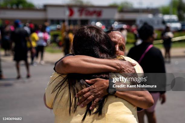 Jeanne LeGall, of Buffalo, hugs another visitor who came to pay their respects at Tops Friendly Market at Jefferson Avenue and Riley Street on...