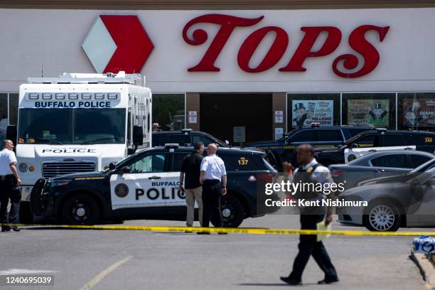 Law enforcement officials are seen at the scene of a mass shooting at Tops Friendly Market at Jefferson Avenue and Riley Street on Sunday, May 15,...