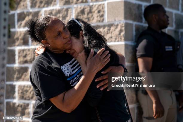 Jeanne LeGall, of Buffalo, hugs Claudia Carballada, of Buffalo, as she gets emotional, as she pays her respects at an makeshift memorial as people...