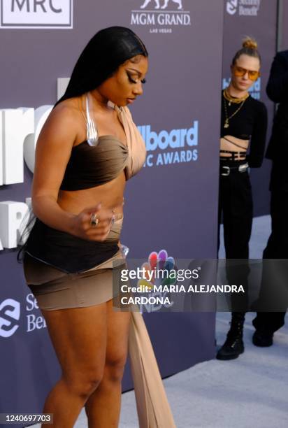 Rapper Megan Thee Stallion attends the 2022 Billboard Music Awards as British model Cara Delevingne peeks from the side at the MGM Grand Garden Arena...