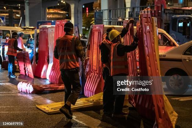 Workers install a fence to seal off a neighborhood at dusk in Guangzhou, Guangdong Province, China, May 15, 2022. COVID-19 Prevention and Control...