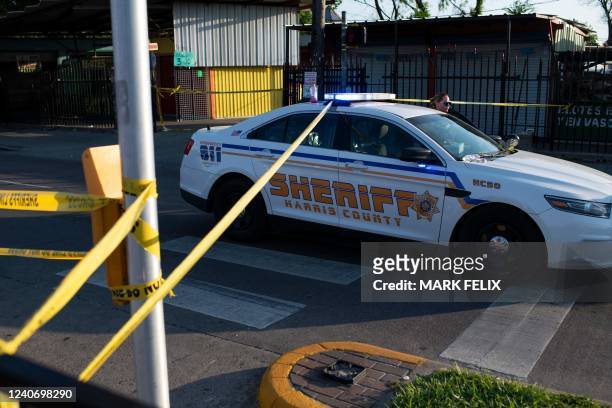 Houston police officer moves their vehicle from outside a crime scene after two people were killed and three more critically injured in a shooting at...