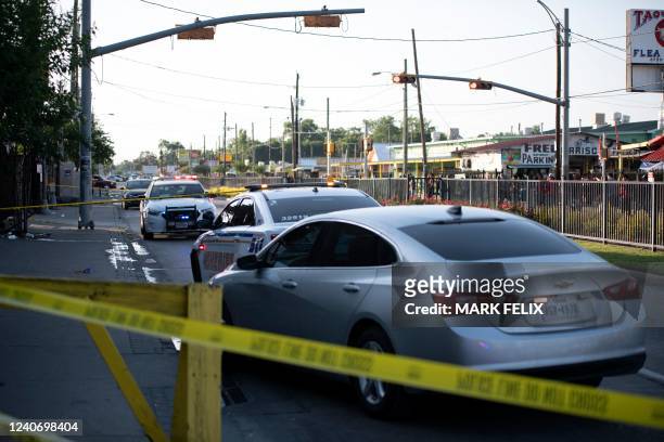 Houston police vehicles are pictured at a crime scene after two people were killed and three more critically injured in a shooting at a flea market...