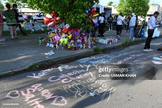 Messages, ballons and flowers are pictured at a makeshift memorial near a Tops Grocery store in Buffalo, New York, on May 15 the day after a gunman...