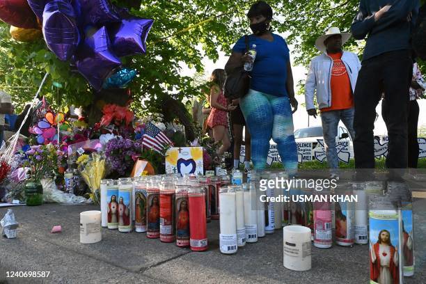 Candles, ballons and flowers are pictured at a makeshift memorial near a Tops Grocery store in Buffalo, New York, on May 15 the day after a gunman...