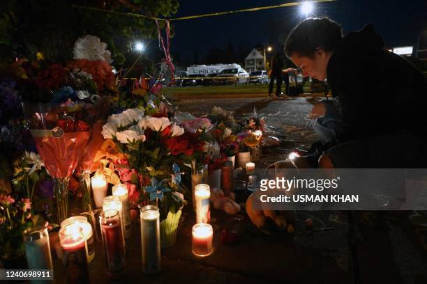People light candles at a makeshift memorial near a Tops Grocery store in Buffalo, New York, on May 15 the day after a gunman shot dead 10 people. -...
