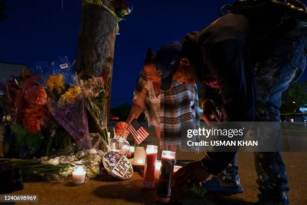 People light candles at a makeshift memorial near a Tops Grocery store in Buffalo, New York, on May 15 the day after a gunman shot dead 10 people. -...