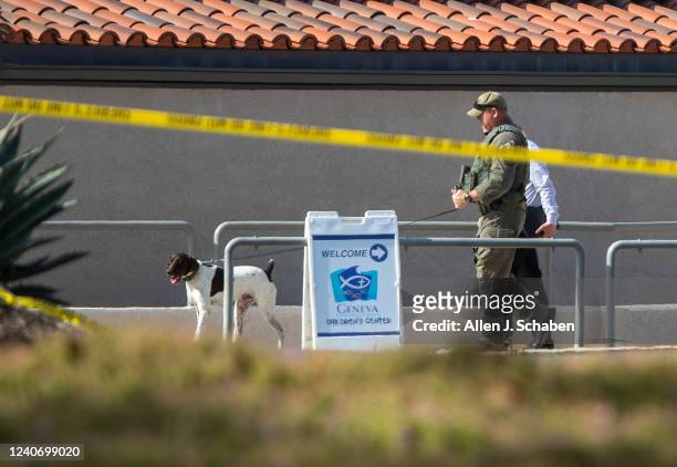 Laguna Woods, CA Orange County Sheriffs Deputy with a bomb-sniffing dog checks the exterior of the church after a person opened fire during a church...