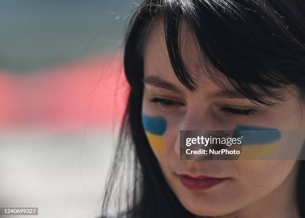 Protester with Ukrainian flags painted on the cheeks. Members of the local Ukrainian diaspora, peace activists and supporters took part in 'Alberta...