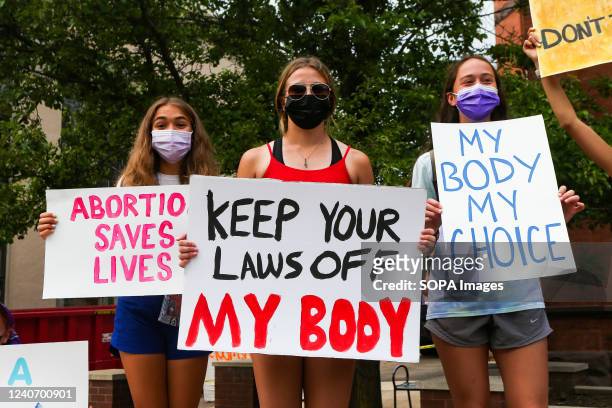 Abortion-rights protesters hold placards during a rally at the Columbia County courthouse. About 100 people attended the rally, which was organized...