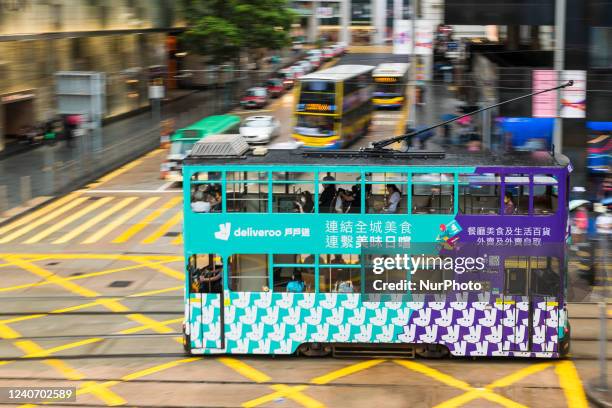 Hong Kong tramway decorated with a publicity for the food delivery company Deliveroo passes in Central Hong Kong in a panned shot, on May 15, 2022.