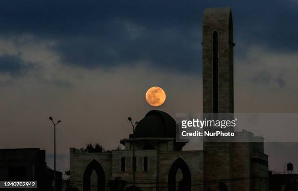 The super flower blood moon appears over Gaza City, May 15, 2022.