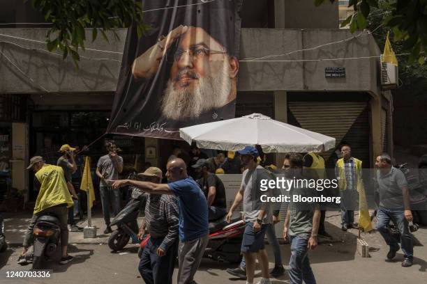 Residents pass a poster featuring Hassan Nasrallah, secretary general of the Hezbollah party, during parliamentary elections in Beirut, Lebanon, on...