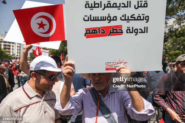 Protestor raises a placard that reads in Arabic, the murder of democracy, the dismantling of state institutions is the imminent danger, during a...