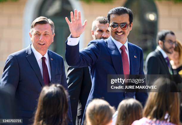 Emir of Qatar Tamim bin Hamad Al Thani , flanked by Slovenias President Borut Pahor , waves upon his arrival for a state visit during a reception...