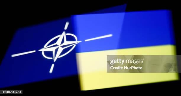 Flags of NATO and Ukraine displayed on phone screens are seen in this multiple exposure illustration photo taken in Krakow, Poland on May 15, 2022.