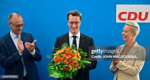 North Rhine-Westphalia's State Premier Hendrik Wuest reacts as leader of Germany's Christian Democratic Union party Friedrich Merz and vice-leader of...