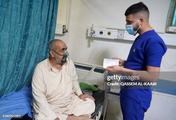 Patient receives medical care at the al-Hakim hospital during a sandstorm in Iraq's holy city of Najaf on May 16, 2022. - Another sandstorm that...