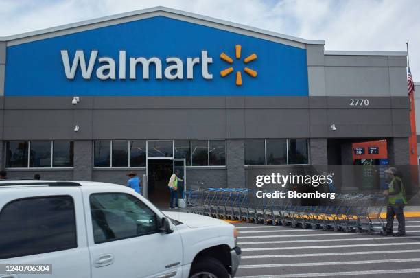 Workers move shopping carts outside a Walmart store in Lakewood, California, US, on Sunday, May 15, 2022. Walmart Inc. Is scheduled to release...