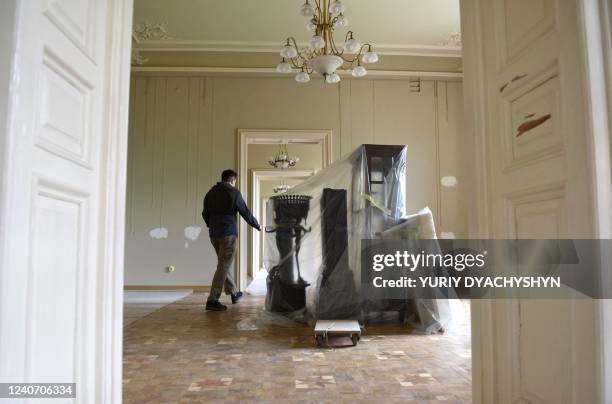 An employee walks past a protectively-wrapped display case in one of the galleries of the Potocki Palace, one of the architectural gems of western...