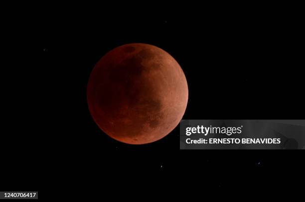 The blood moon is seen during a total lunar eclipse in Canta, east of Lima on May 15, 2022.