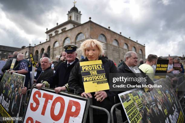 Man wearing a Boris Johnson mask stands with fellow Border Communities against Brexit campaigners as they stage a protest outside Hillsborough castle...