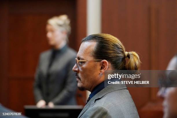 Actors Amber Heard and Johnny Depp watch as the jury comes into the courtroom after a break at the Fairfax County Circuit Courthouse in Fairfax,...