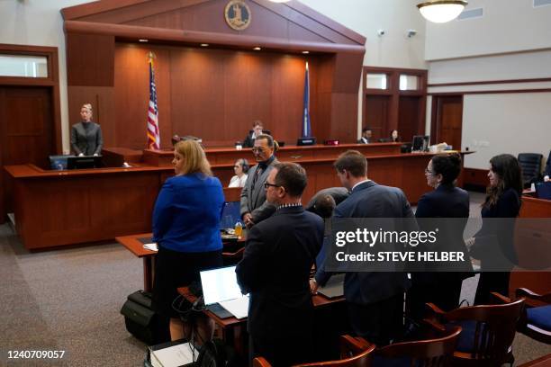 Actors Amber Heard and Johnny Depp watch as the jury leaves the courtroom for a break at the Fairfax County Circuit Courthouse in Fairfax, Virginia,...