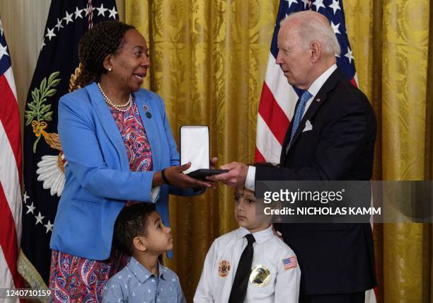 President Joe Biden presents the Medal of Valor to Sabrail Davenport, on behalf of her fallen son Jared Lloyd, of the Spring Valley Fire Department...