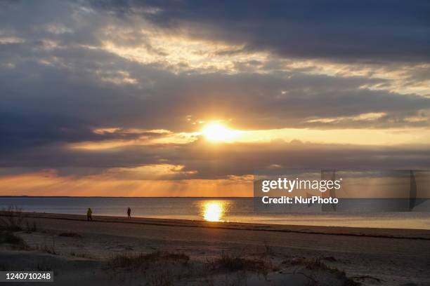 People walking at the beach during a sunset are seen in Jurmala , Latvia on 5 May 2022 Jurmala is a resort town about 25 km west of Riga, sandwiched...