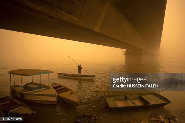Fisherman paddles his boat during a sandstorm in Iraq's southern city of Basra on May 16, 2022. - Another sandstorm that descended on...