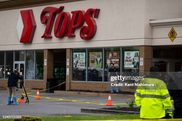 Bullet holes are seen in the window of Tops Friendly Market at Jefferson Avenue and Riley Street, as federal investigators work the scene of a mass...