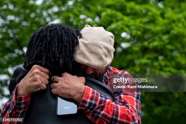 Derek Middlebrooks, of Buffalo, is hugged by Sean Storms, of North Tanawanda, near the scene of a mass shooting at Tops Friendly Market at Jefferson...