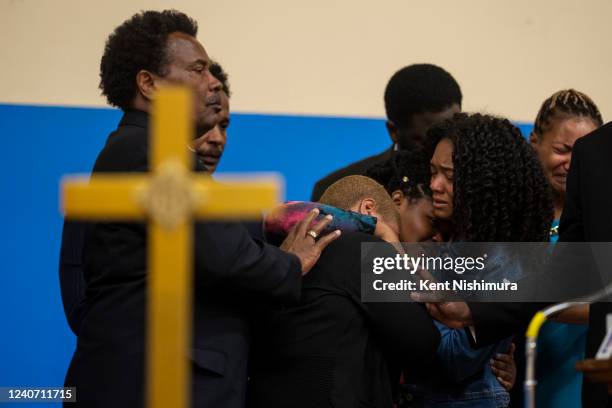 Tiffany Whitfield, left, and Lauren Gibson, right, comforts Laurell Robertson, center, during a news conference with Attorney Ben Crump and other...