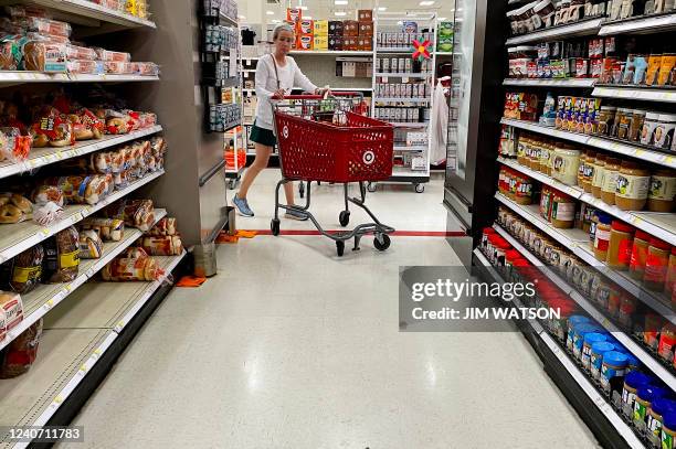 Woman pushes a shopping cart through the grocery aisle at Target in Annapolis, Maryland, on May 16 as Americans brace for summer sticker shock as...