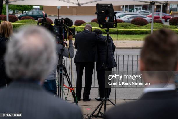 Attorney Ben Crump, center left, comforts Garnell Whitfield Jr., during a television interview across the street from Tops Friendly Market at...