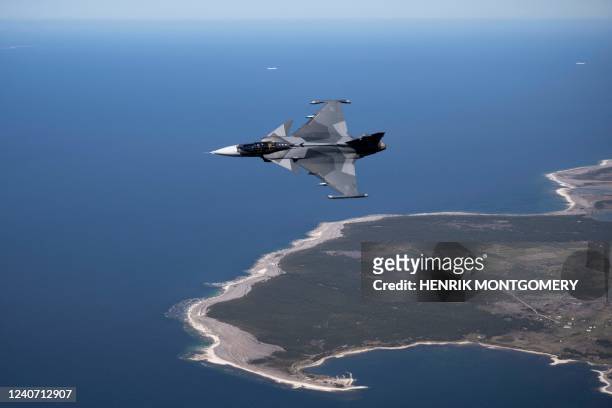 Swedish airforce Jas 39 Gripen E jet fighter flies over Gotland island in the baltic sea on May 11, 2022. - Sweden will apply for membership in NATO...