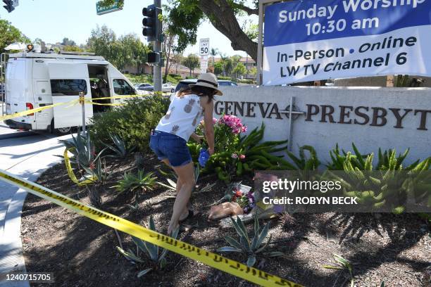 Woman places flowers at a makeshift memorial outside the Geneva Presbyterian Church May 16, 2022 after one person was killed and five injured during...