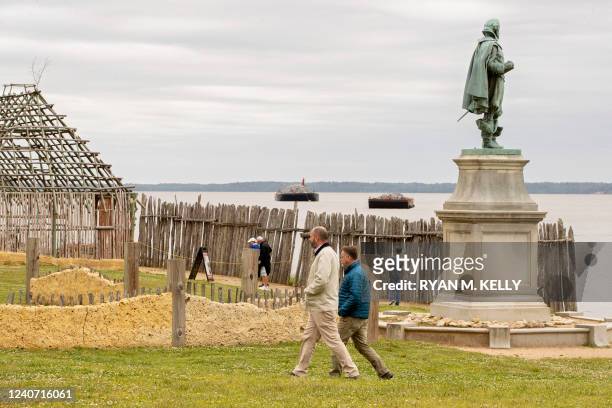 Michael Lavin, director of collections, and David Givens, director of archaeology, walk past a statue of John Smith at Jamestown, Virginia, on May...