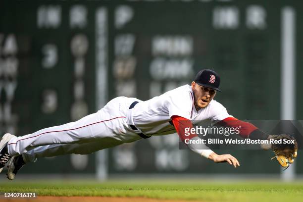 Trevor Story of the Boston Red Sox makes a diving stop during the third inning of a game against the Houston Astros on May 16, 2022 at Fenway Park in...