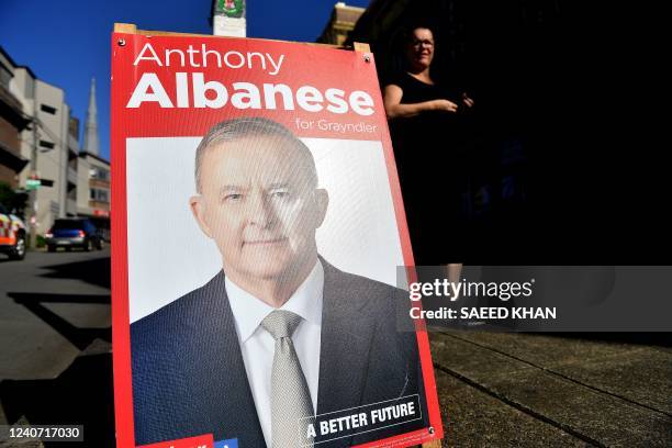 Resident walks past a pre-polling station as a poster of Australian Opposition Leader Anthony Albanese is seen, in the Marrickville suburb of Sydney...