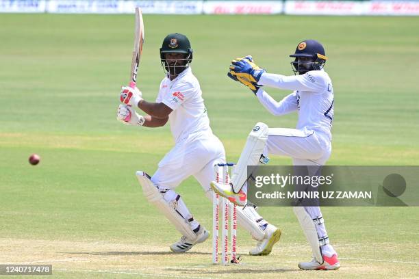 Bangladesh's Tamim Iqbal plays a shot as Sri Lanka's wicketkeeper Niroshan Dickwella watches during the third day of the first Test cricket match...