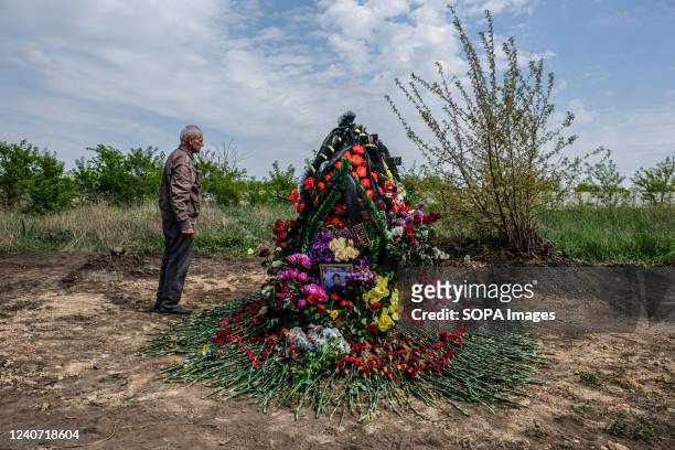 Father stands in front of the grave of his son, Sergey Titov, 32 years old, sergeant of the National Guard, killed by a Russian shelling in Balabyne...