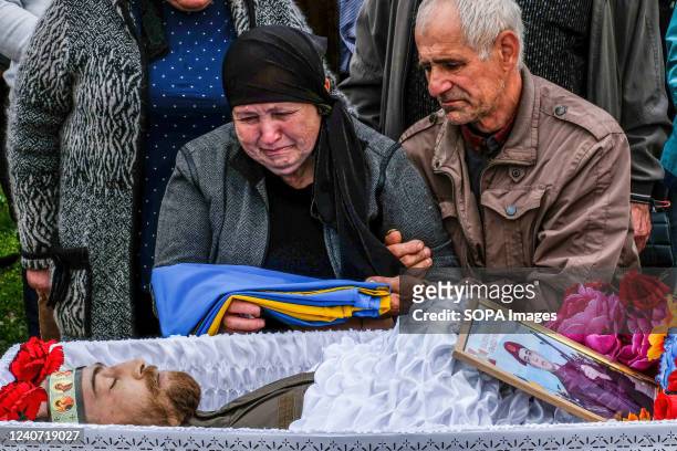 Parents of Sergey Titov, 32 years old, sergeant of the National Guard, killed by a Russian shelling in Balabyne village, sit by his coffin at the...