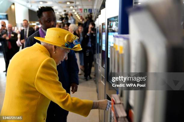 Queen Elizabeth II using a oyster card machine as she attends the Elizabeth line's official opening at Paddington Station on May 17, 2022 in London,...