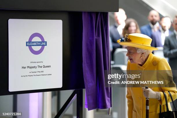 Britain's Queen Elizabeth II unveils a plaque to mark the official opening of the 'Elizabeth Line' rail service at Paddington Station in London on...