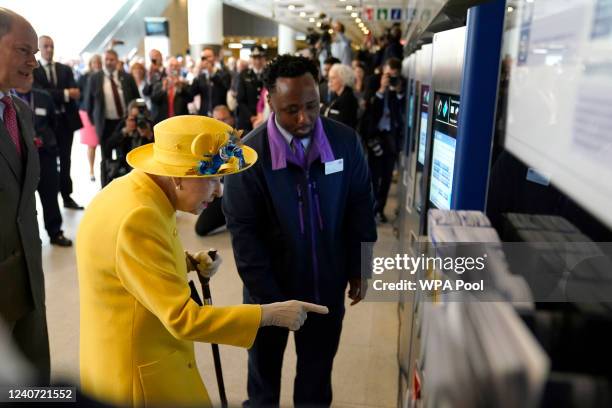 Queen Elizabeth II using a oyster card machine as she attends the Elizabeth line's official opening at Paddington Station on May 17, 2022 in London,...