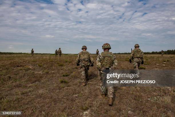 Officers watch as members of the 182d Infantry Regiment work in concert as small squads and fire on targets in a field as they train for deployment...