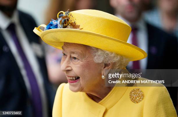 Britain's Queen Elizabeth II reacts during her visit to Paddington Station in London on May 17 to mark the completion of London's Crossrail project,...